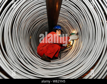 --FILE--un lavoratore cinese lucidi a spirale in acciaio inossidabile aste presso un impianto di Dongbei acciaio speciale Group Co., Ltd. nella città di Dalian, a nord-est della Cina di Li Foto Stock