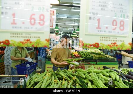 --FILE--i clienti cinesi shop per ortaggi in un supermercato in Hangzhou, est della Cina di provincia dello Zhejiang, 10 luglio 2016. La Cina del consumatore pric Foto Stock