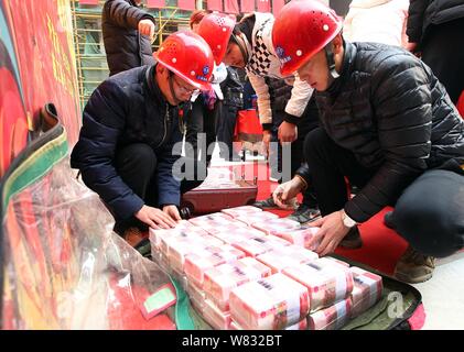 Cinese i lavoratori migranti ottenere fasci di 100-yuan RMB (Renminbi) banconote per i loro stipendi e premi di fine anno presso il cantiere per la costruzione di una vera e propria es Foto Stock