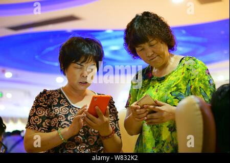 --FILE-Le donne cinesi utilizzano il loro smartphone per navigare in Internet in Yichang city, centrale cinese della provincia di Hubei, 14 giugno 2015. Circa 695 milioni di C Foto Stock