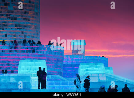 I visitatori guardano illuminato sculture di ghiaccio durante il XVIII Cina Harbin Ice-Snow Mondo 2017 nella città di Harbin, a nord-est della Cina di Provincia di Heilongjiang, Foto Stock