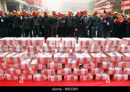 Fasci di 100-yuan RMB (Renminbi) banconote per stipendi e premi di fine anno dei lavoratori migranti sono impilati fino al luogo di costruzione di una vera e propria es Foto Stock