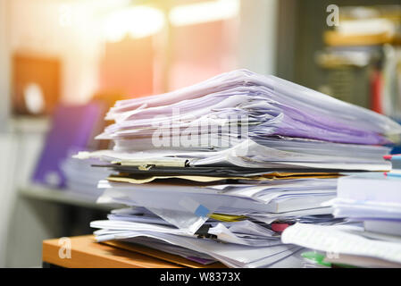 Molto lavoro documento di lavoro file di pile di documenti cartacei nella ricerca di informazioni su scrivania ufficio / business report paper pile incompiuta sulla scheda Foto Stock