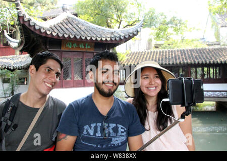 --FILE--i turisti stranieri rappresentano per le foto nel giardino Zhuozheng in Suzhou City, est cinese della provincia di Jiangsu, 22 settembre 2016. La Cina è diventata Foto Stock