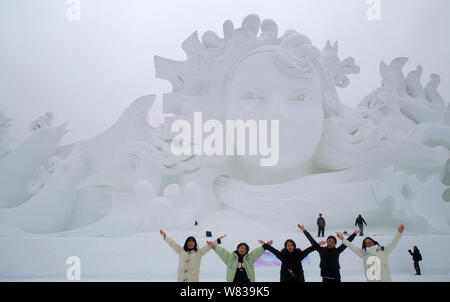 Visitatori pongono le foto davanti alla scultura di neve "Love Song' durante la XXIX Harbin Sun Island International Snow Sculpture Art Expo nella città di Harbin Foto Stock