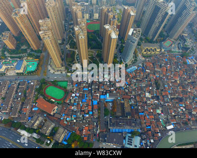 --FILE -- Una veduta aerea di una baraccopoli con vecchie case accanto a grappoli di alto e moderno appartamento residenziale fabbricati in Cina a Shanghai, 7 Dece Foto Stock