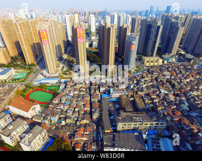 --FILE -- Una veduta aerea di una baraccopoli con vecchie case accanto a grappoli di alto e moderno appartamento residenziale fabbricati in Cina a Shanghai, 27 Mar Foto Stock