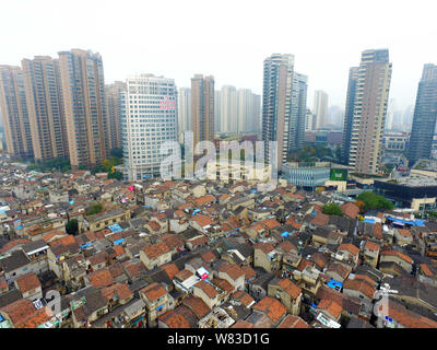 --FILE -- Una veduta aerea di una baraccopoli con vecchie case accanto a grappoli di alto e moderno appartamento residenziale fabbricati in Cina a Shanghai, 7 Dece Foto Stock