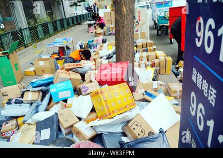 --FILE--studenti cinesi cerca in una massa di pacchi, la maggior parte delle quali sono camere singole al giorno online shopping, di fronte ad una porta di una università in Beijin Foto Stock