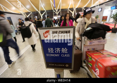 --FILE--i passeggeri in coda fino a ottenere delle carte di imbarco e hanno i loro bagagli controllati in davanti di un contatore di Air China a Shanghai Pudong intern Foto Stock