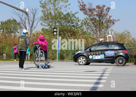 --FILE--un driverless vettura viaggia su strada durante il 2016 la Cina Veicolo intelligente campionato in Cina a Shanghai, 3 dicembre 2016. La Cina sarà r Foto Stock