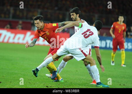 Zhang Linpeng della Cina, sinistra, sfida i giocatori del Qatar nel loro gruppo un Round 3 match durante la Coppa del Mondo FIFA 2018 qualificatori asiatici in finale Kunm Foto Stock