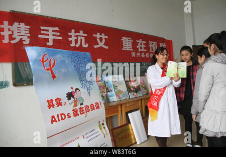 Un medico cinese lavoratore propagandizes prevenzioni di HIV e AIDS a studenti di sesso femminile a una formazione professionale e scuole tecniche nella contea di inscatolamento, Binzhou c Foto Stock