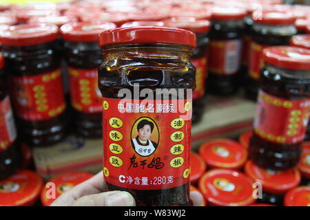 --FILE--un acquirente acquista una bottiglia di Lao Gan Ma o Laoganma salsa chili in un supermercato in città Xuchang, centrale cinese della provincia di Henan, 8 febbraio 201 Foto Stock