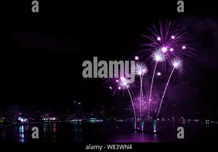 Impressionante vivid color porpora fuochi d'artificio schizzi nel cielo di notte sul porto Foto Stock