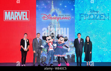 I dirigenti e gli animatori vestiti con i costumi di Micky Mouse e Minnie Mouse pongono durante una presentazione su Hong Kong Disneyland resort dell'espansione Foto Stock