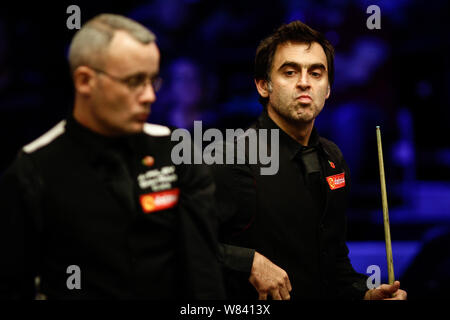 Ronnie O'Sullivan dell Inghilterra, indietro, reagisce come egli ritiene che un colpo contro Martin Gould di Inghilterra nel loro quarterfinal match durante il campione del 2016 Foto Stock