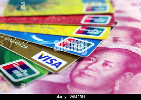 --FILE--Carte di debito e carte di credito emesse da banche cinesi supportato dalla Cina UnionPay e Visa sono collocati su RMB (renminbi yuan) banconote in Ji'nan city Foto Stock