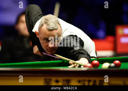 Martin Gould di Inghilterra gioca un colpo contro Ronnie O'Sullivan di Inghilterra nel loro quarterfinal match durante il 2016 campione dei campioni di biliardo Foto Stock