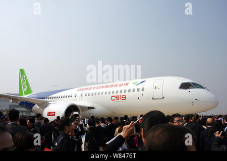 --FILE -- gente guarda alla Cina il primo in casa passeggeri di grandi dimensioni jet C919 durante una cerimonia in modalità non in linea alla finale dello stabilimento di assemblaggio di COMAC (aria commerciale Foto Stock