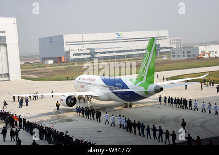 --FILE--Cina il primo in casa passeggeri di grandi dimensioni jet C919 viene trainato al di fuori di un hangar durante una cerimonia in modalità non in linea alla finale dello stabilimento di assemblaggio di COMAC Foto Stock