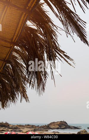 Vista dal basso il tetto di foglie di palma da cocco albero sulla riva del mare di viaggio concetto d'estate. Foto Stock