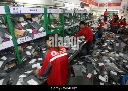 --FILE--lavoratori cinesi ordinamento pacchi, la maggior parte dei quali sono da shopping online, presso un centro di distribuzione delle migliori Express in Hangzhou, est della Cina di Foto Stock