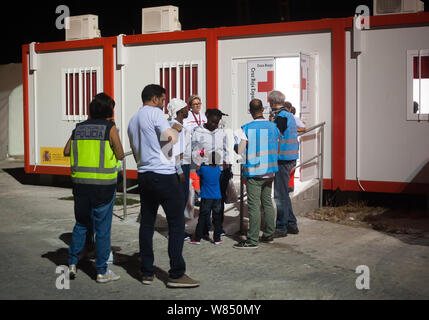 Malaga, Spagna. 07 Ago, 2019. I migranti donne e un bambino sono visti al di fuori di una situazione di emergenza umanitaria in stallo come parlano con i membri della Comunità di confine e della Guardia costiera (Agenzia Frontex) dopo il loro arrivo al porto di Malaga. Spagna's Maritime Rescue service salvato un totale di 73 migranti a bordo di un battello che attraversa il Alboran Mare e li ha portati al porto di Malaga, dove sono stati assistiti dalla Croce Rossa spagnola. Circa 163 immigrati sono stati liberati durante le ultime ore. Credito: SOPA Immagini limitata/Alamy Live News Foto Stock