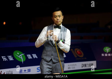 Marco fu di Hong Kong i gessi spunto come egli ritiene che un colpo contro David Gilbert di Inghilterra durante il loro match di primo turno del 2016 World Snooker Foto Stock