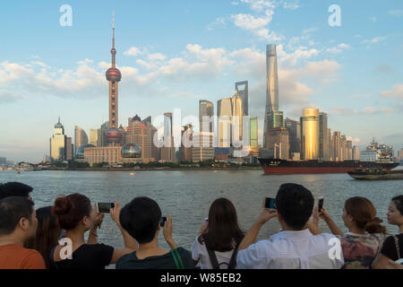 --FILE--i turisti in visita alla passeggiata sul Bund per scattare foto del paesaggio urbano del Quartiere Finanziario di Lujiazui con la Oriental Pearl TV per Foto Stock