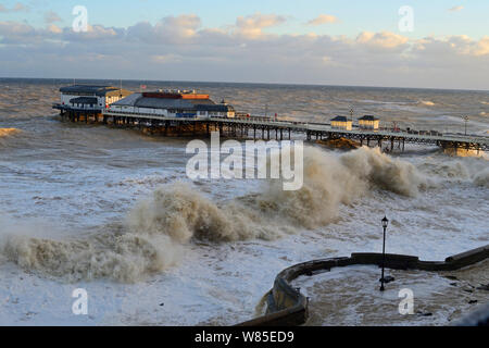 Alte onde rizzatura Cromer lungomare e il molo durante la mareggiata., Norfolk, Inghilterra, Regno Unito. Dicembre 2013. Foto Stock