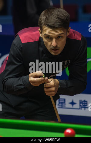 Michael Holt di Inghilterra chalks spunto come egli ritiene che un colpo contro Ding Junhui della Cina durante i loro quarti del 2016 World Snooker Shangha Foto Stock