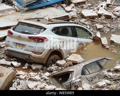 Le automobili private sono immerse in acqua dopo essere stata lavata da inondazioni causate da un acquazzone in una buca dal parcheggio in un quartiere residenziale in Foto Stock