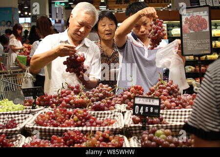 --FILE--i clienti cinesi shop per le uve ad un supermercato in città Xuchang, centrale cinese della provincia di Henan, 31 luglio 2016. La Cina è fiducioso di reac Foto Stock