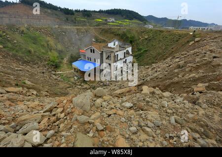 Un chiodo casa il cui proprietario ha rifiutato di spostare a causa di dispute sui dettagli di compensazione è isolato in una fossa presso il cantiere per la costruzione di un settore industriale Foto Stock