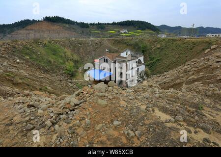 Un chiodo casa il cui proprietario ha rifiutato di spostare a causa di dispute sui dettagli di compensazione è isolato in una fossa presso il cantiere per la costruzione di un settore industriale Foto Stock