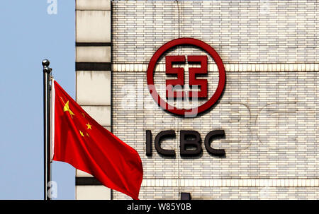 --FILE--La bandiera nazionale cinese sventola davanti a un logo di ICBC (industriale e banca commerciale della Cina) a Chongqing Cina, 28 giugno 2016. Ind Foto Stock
