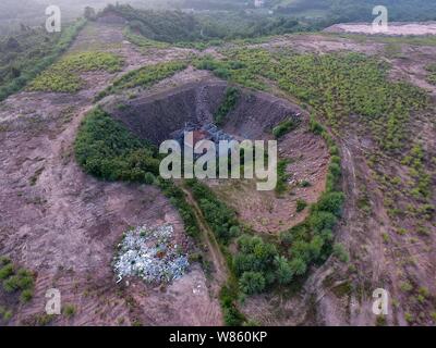 Un chiodo casa il cui proprietario ha rifiutato di spostare a causa di dispute sui dettagli di compensazione è isolato in una fossa presso il cantiere per la costruzione di un settore industriale Foto Stock