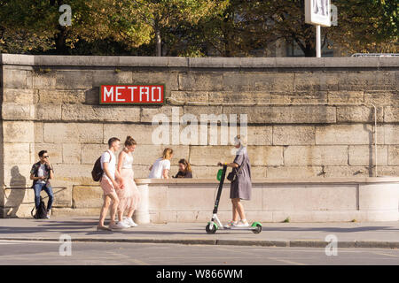 Paris Street scene pomeriggio - equitazione donna scooter elettrico vicino al Concorde La stazione della metropolitana di Parigi, in Francia, in Europa. Foto Stock