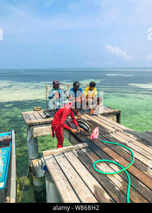 Fehendhoo isola, Maldive - Aprile 1, 2018: maldiviano pescatore locale è il pesce di taglio sul molo su Fehendhoo isola. La pesca è la principale attività Foto Stock