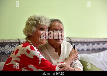 Maria Previte dagli Stati Uniti, a sinistra, abbracci Wang Chenghan che hanno salvato la sua 71 anni fa come essi si riuniscono a Wang casa nella città di Guiyang, southwest C Foto Stock