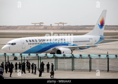 --FILE--le persone scattano foto o guardare un Boeing 737-800 jet passeggeri delle compagnie aeree Donghai a Shenzhen Baoan International Airport nella città di Shenzhen Foto Stock