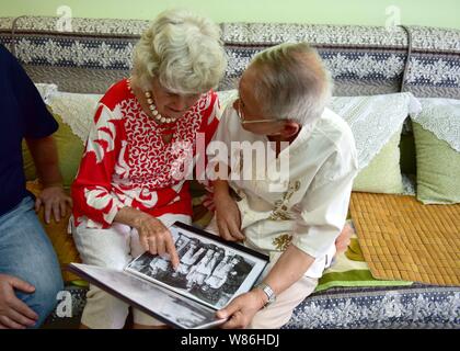 Maria Previte dagli Stati Uniti, a sinistra, e Wang Chenghan che hanno salvato la sua 71 anni fa rivedere le vecchie foto come essi si riuniscono a Wang home di Guiyang Foto Stock