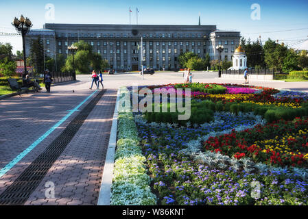Russia, Irkutsk - Luglio 7, 2019: Casa dei Soviet, del governo della Regione di Irkutsk, letto di fiori e la cappella e nel centro della città in Tikhvinsky o Kirov Foto Stock