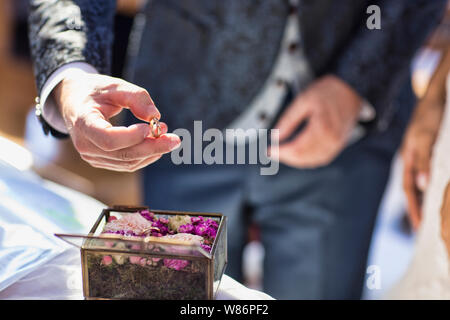 Dettaglio del momento quando lo sposo prende il suo anello di nozze lo scambio con la sposa all'altare Foto Stock