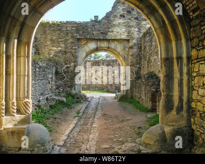 Portale in stile romanico, corridoio tra pareti di pietra. Questo portale è situato nella fortezza di Suceava, Romania Foto Stock