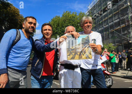 Londra REGNO UNITO. 8 agosto 2019.Una ventola tiene il coperchio originale di Abbey Road album con il gruppo dei Beatles John Lennon, Paul MacCartney, Ringo Starr e George Harrison ona zebra crossing in occasione del cinquantesimo anniversario del rilascio in data 8 agosto 1969.Credit: amer ghazzal/Alamy Live News Foto Stock