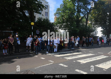 Londra, Regno Unito. 8 Ago, 2019. Gli appassionati di musica di ricreare la celebre passeggiata sulle strisce pedonali dai Beatles John Lennon, Paul McCarney, Ringo Starr e George in occasione del cinquantesimo anniversario della Abbey Road album pubblicato il 8 agosto 1969. Credito: amer ghazzal/Alamy Live News Foto Stock