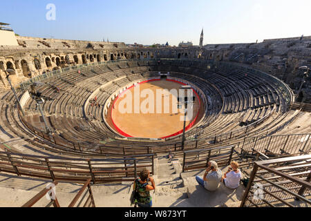 Nimes (sud-est della Francia): i visitatori con audio guide all'interno dell'arena di Nimes, anfiteatro romano registrati come una pietra miliare storica nazionale (Fre Foto Stock