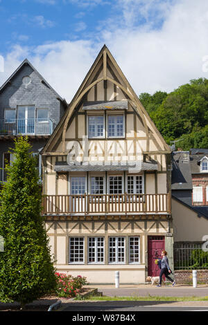 Una tradizionale casa della Normandia in Honfleur, Francia come una ragazza da passeggiate con il suo cane Foto Stock